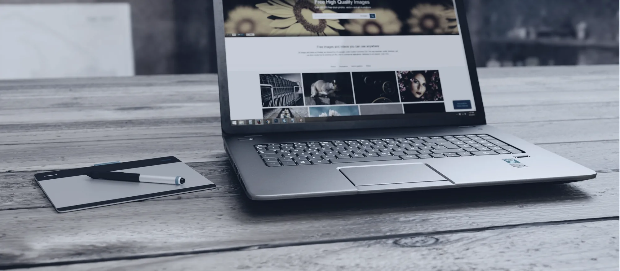 Werkplek met laptop en tekentablet waarop een website wordt gebouwd