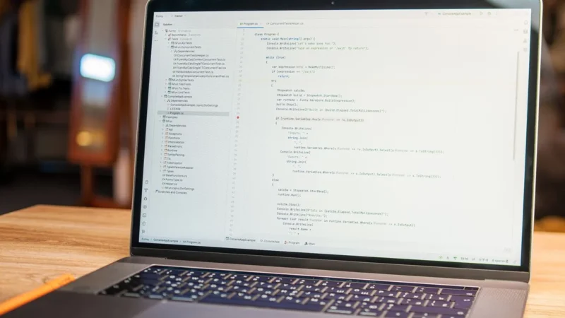 Laptop op een houten bureau met programmacode op het scherm